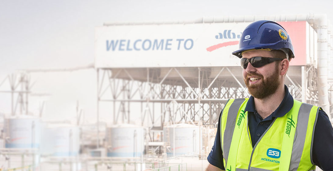 Photograph of a man wearing a hard hat, sunglasses and an ESB International high vis vest
