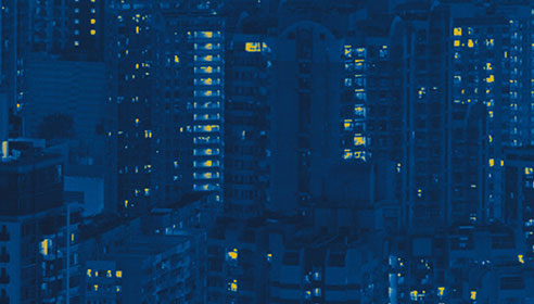 Stylised image of tall buildings with lights turned on