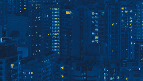 Stylised image of tall buildings with lights turned on
