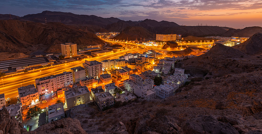 Photograph of a build up area among some mountains taken at night