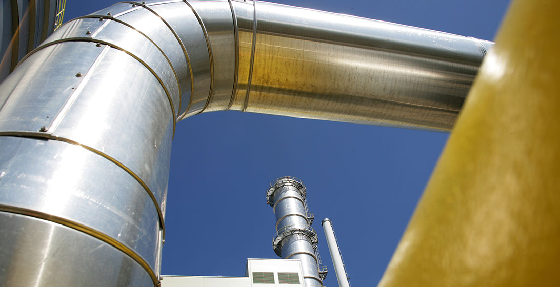Photograph of a large metal pipe outside a power station