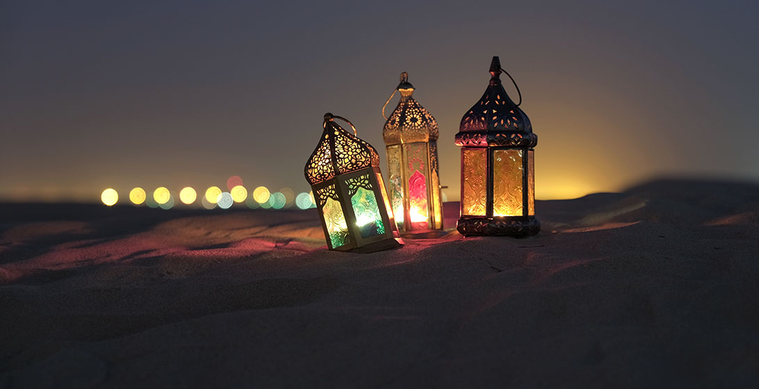 Photograph of three ornate laterns on the sand