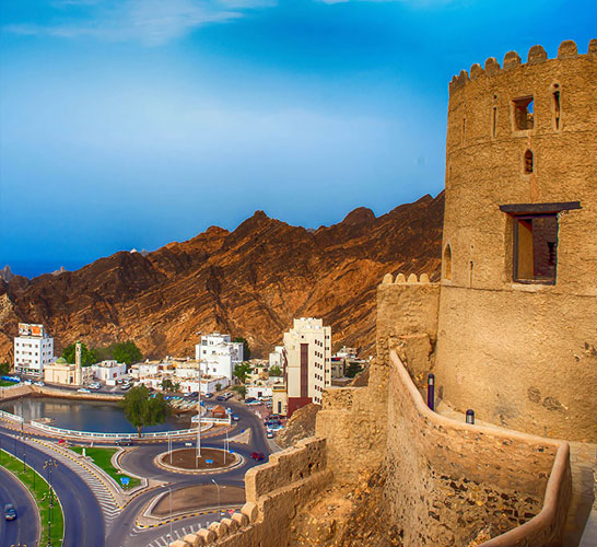 Image of a coastal road and a castle like building with a turret taken at night time
