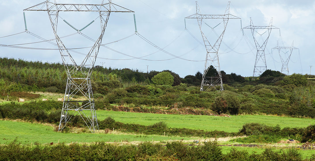 Photograph of pylons in green fields