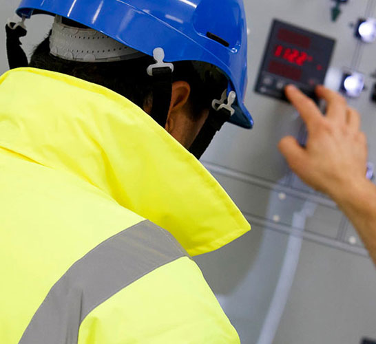 Man in safety gear inspecting machinery
