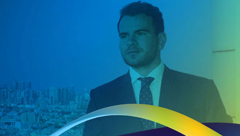 Photograph of Mark Mooney with city in the background. There is a blue to yellow gradient overlay applied to the image